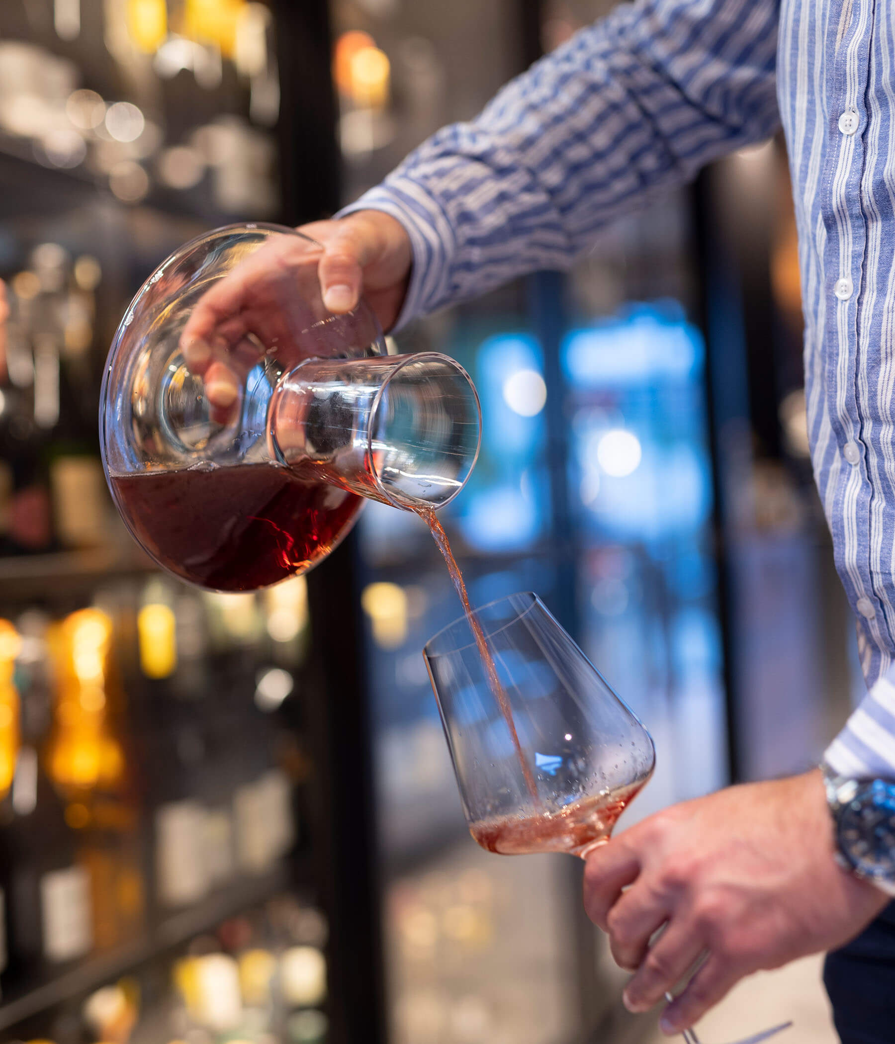 Wine from a decanter is poured into a glass